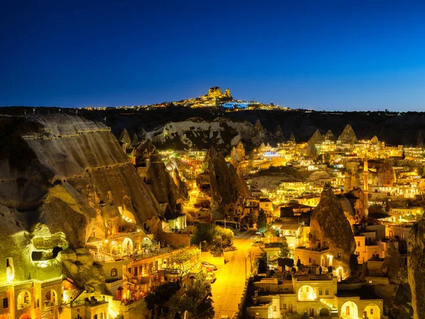 Goreme, Kapadokya, Türkiye. Dağdan akşam şehri manzarası. Parlak bir şehir ve berrak bir gökyüzü. Yaz mevsiminde manzara. Tatil ve turizm.