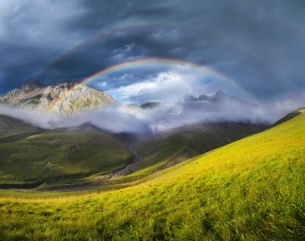 Rainbow in mountain valley Stock Photo