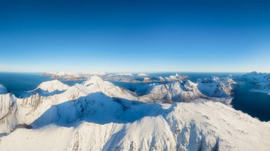 Flight over the mountains. Scandinavia. Aerial view on the Lofoten Islands, Norway. Wide panoramic view of the north. Natural winter landscape from air. Photo for postcards, backgrounds, wallpapers.