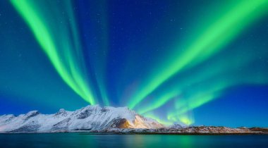 İskandinavya 'daki Aurora Borealis. Norveç, Lofoten adaları. Dağların üzerinden kuzey ışıkları. Yıldızlı gökyüzü. Kuzeyde kış manzarası. Arkaplan, duvar kağıdı, kartpostallar için fotoğraf.