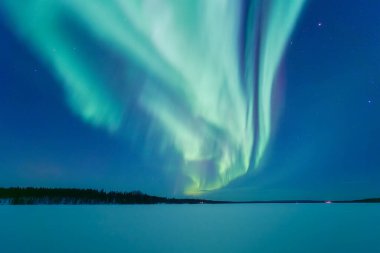 İskandinavya 'daki Aurora Borealis. Kuzey ışıkları donmuş göl ve ormanın üzerinde. Yıldızlı gökyüzü. Gökyüzünde parlıyor. Kuzeyde kış manzarası. Resimli bir manzara. Arkaplan, duvar kağıdı, kartpostallar için fotoğraf. 