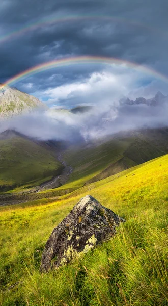 Rainbow in mountains valley — Stock Photo, Image