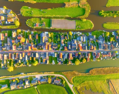 Hollanda 'nın kırsal bir köyünün insansız hava aracı görüntüleri. Simetrik kanallar ve geleneksel evler yeşil tarım alanlarıyla geometrik bir model oluşturur. Hollanda 'da. Otantik Hollanda 'nın kuş bakışı görüntüsü.