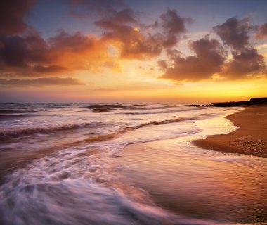 Renkli gün batımı sırasında deniz manzarası