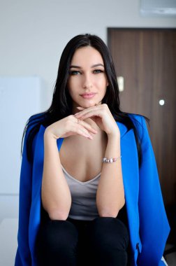 Confident, young woman with blue jacket. Beautiful brunette, Miss Lower Silesia poses at home, indoor photo session. 