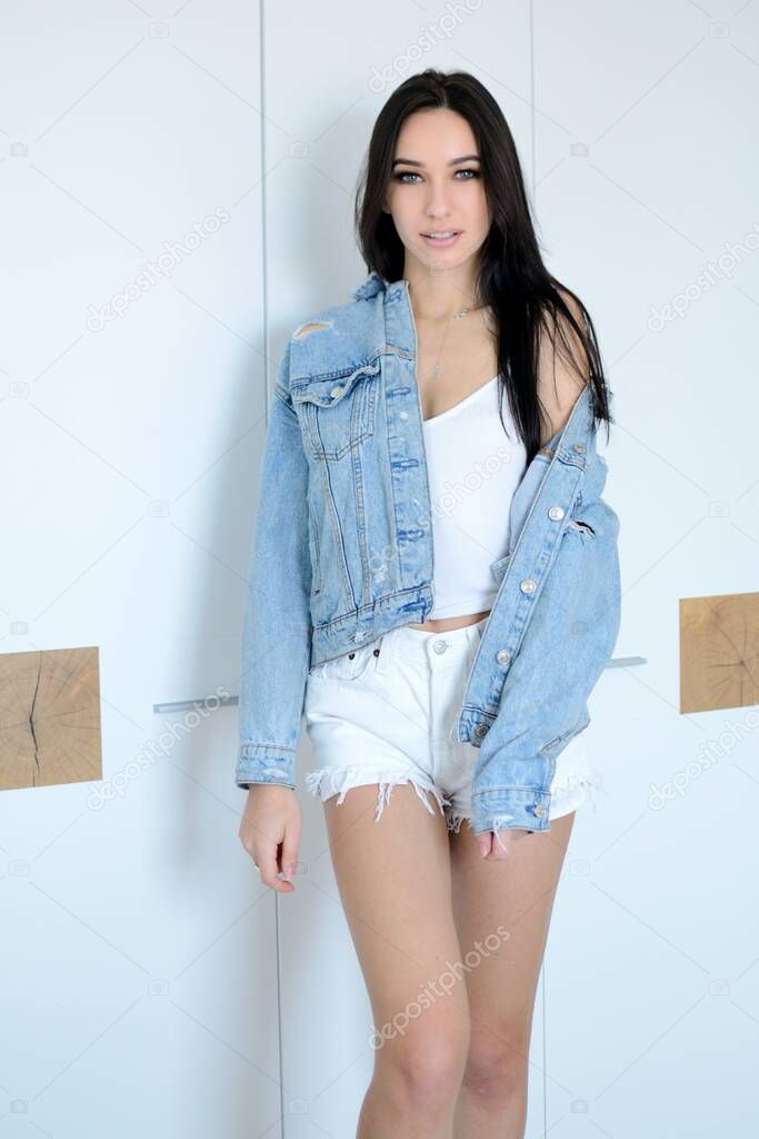 Young woman next to her wardrobe. Beautiful brunette, Miss Lower Silesia poses at home, indoor photo session. 