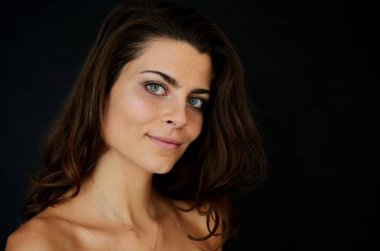 Stüdyoda siyah geçmişi olan genç Polonyalı bir kadın. Nazik bir gülümsemeyle portre. 