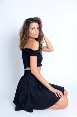 Stüdyodaki genç Polonyalı kadın. Siyah bluzlu, siyah etekli, ince saçlı kadın..