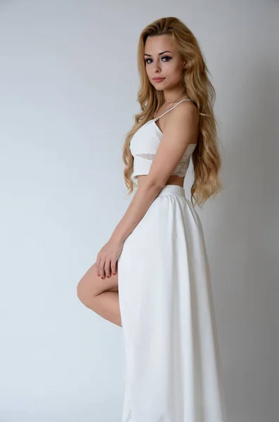 ポーランドのモデルポージングとともにホワイトトップ 長い白いドレスでカット 彼女の足を示す — ストック写真