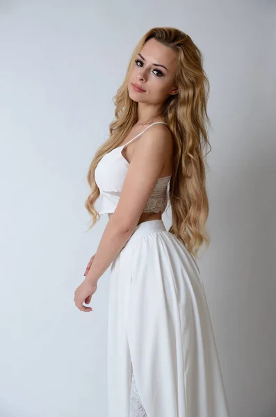 ポーランドのモデルポージングとともにホワイトトップ 長い白いドレスでカット 彼女の足を示す — ストック写真