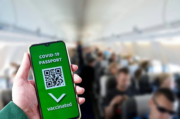 Traveling during SARS-CoV-19 pandemic. Travelling by plane with Covid-19 passport application in mobile phone.