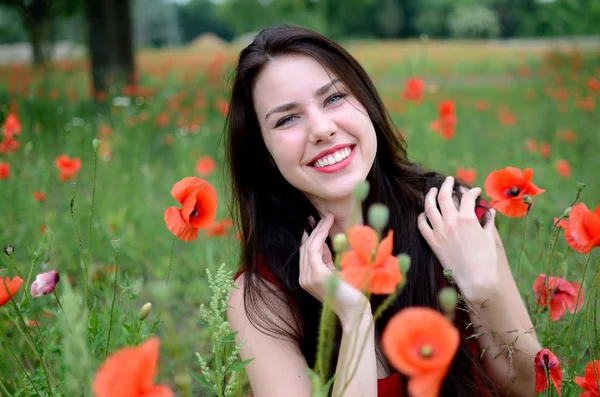 Menina sorridente com papoilas — Fotografia de Stock