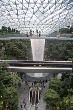 SINGAPORE, 22 Haziran 2019: Singapur Jewel Changi Havalimanı içinde yer alan 40 metre uzunluğunda kapalı bir şelale olan Yağmur Girdabı 'nı izleyen tanımlanamayan kişiler. Jewel Changi Havaalanı 17 Nisan 2019 'da açılacak..