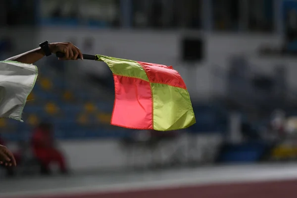 Assistant referee hold flag , offside signal