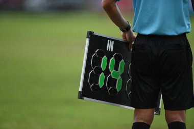 Assistant referee hold substitution board for changing player side the pitch