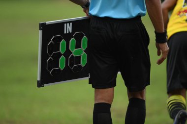 Assistant referee hold substitution board for changing player side the pitch