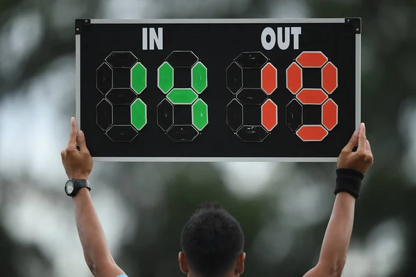Assistant referee hold substitution board for changing player side the pitch
