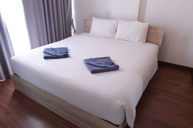 Rahat yatak, beyaz çarşaflar ve iki havlu.