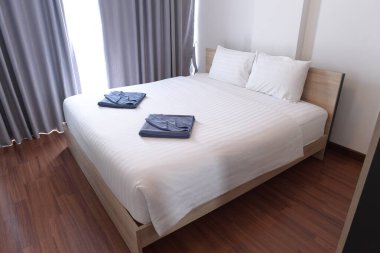 Rahat yatak, beyaz çarşaflar ve iki havlu.