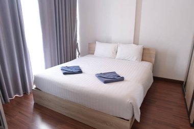 Rahat yatak, beyaz çarşaflar ve iki havlu.