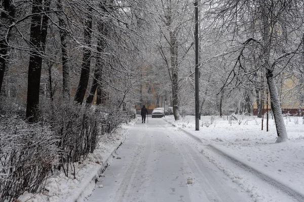 Karda tek başına yürüyen kişi. Moskova 'da kış eski moda avlu.