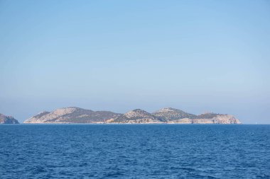 Sis içinde dağlık bir ada. Denizin manzarası..