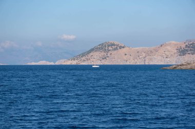Denizdeki ada ve yalnız beyaz tekne. Denizin manzarası..