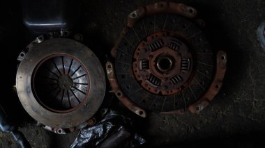 Kirli ve hasarlı bir araba parçası yağ kalıntılarıyla kaplı. Kirli, aşınmış ve otomotiv bakım ortamını gösteren yakın plan ayrıntılar