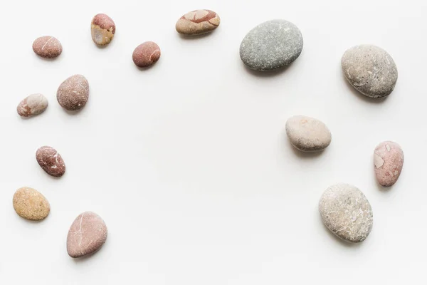 Beyaz arkaplanda deniz taşları, pürüzsüz taşlar.