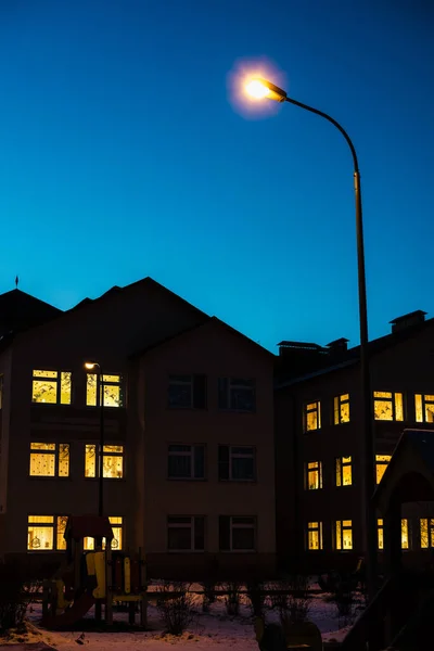 Evin pencerelerinde ışıklar, gece evi, evin yanındaki ışıklar, gece kenti, sarı ışıklı pencereler, konut binaları. 