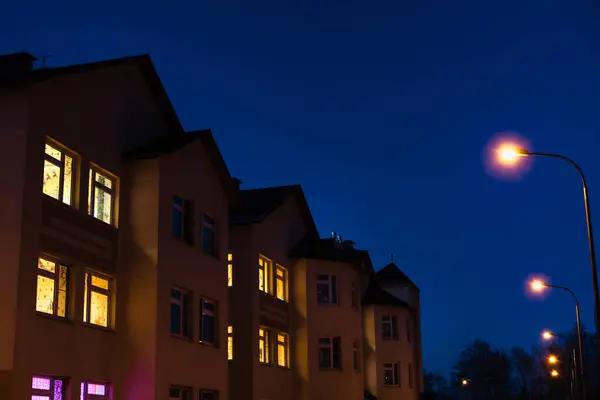 Evin pencerelerinde ışıklar, gece evi, evin yanındaki ışıklar, gece kenti, sarı ışıklı pencereler, konut binaları. 