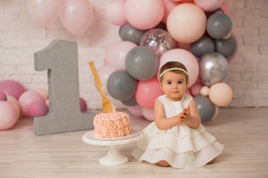 İlk doğum gününde küçük bir kız ve pasta.