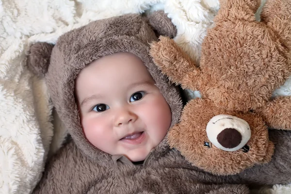 Ребенок в костюме медведя с игрушечным медведем — стоковое фото