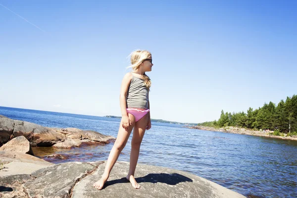 Gyermek a sziklás strand, Svédország — Stock Fotó