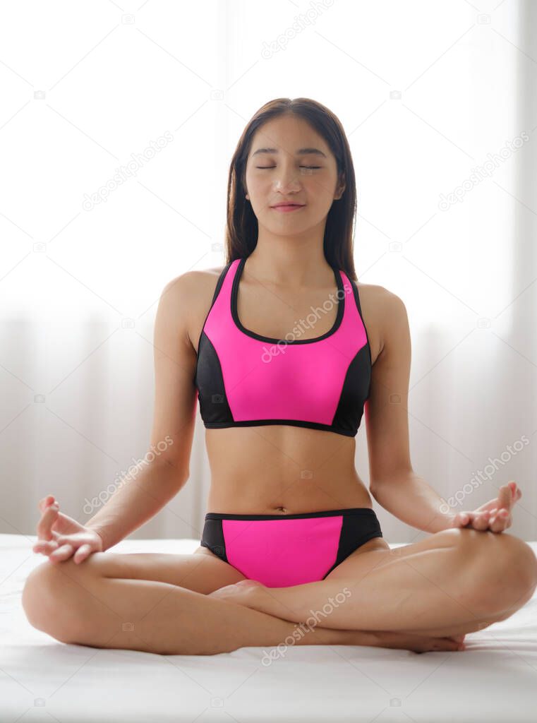 Asian woman with bikini exercise yoga in a home environment