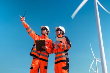 Mühendisler elektrik üretmek için rüzgar türbinlerini inceliyorlar..
