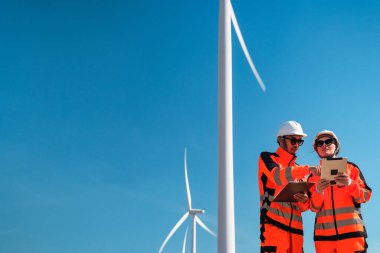 Mühendisler elektrik üretmek için rüzgar türbinlerini inceliyorlar..