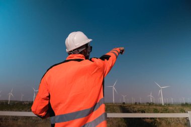 Mühendisler elektrik üretmek için rüzgar türbinlerini inceliyorlar..