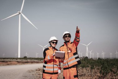 Mühendisler elektrik üretmek için rüzgar türbinlerini inceliyorlar..