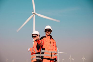 Mühendisler elektrik üretmek için rüzgar türbinlerini inceliyorlar..