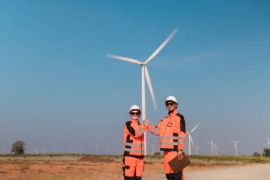 Mühendisler elektrik üretmek için rüzgar türbinlerini inceliyorlar..