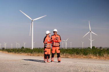 Mühendisler elektrik üretmek için rüzgar türbinlerini inceliyorlar..