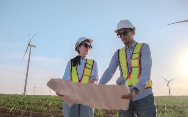 Mühendisler elektrik üretmek için rüzgar türbinlerini inceliyorlar..