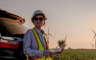 Mühendisler elektrik üretmek için rüzgar türbinlerini inceliyorlar..