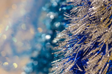 Bokeh 'li Noel çelenklerinin soyut renkli arkaplanı. Tasarımcı için boş. Bulanık. Mavi, sarı ve altının hakimiyeti.