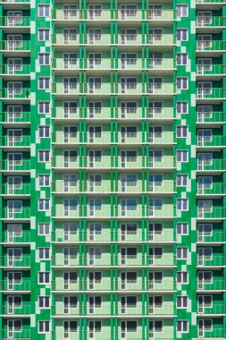 Siyahi görünüşlü modern bir binanın yüzü. Pencereleri ve balkonları olan modern bir binanın duvarının bir parçası..