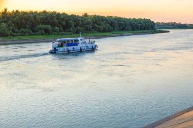 Yolcuları olan küçük bir eğlence gemisi akşam üzeri Irtysh Nehri boyunca yelken açar. Omsk, Rusya - 31 Temmuz 2021.