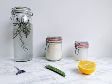 Lavanta, aloe vera ve limon gibi doğal malzemelerle birlikte kumaş yumuşatıcı ve çamaşır deterjanı gibi DIY temizlik ürünleri.