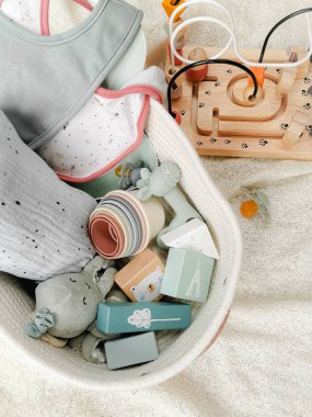 Bebek partisi için yumuşak renkli oyuncaklarla hazırlanmış cinsiyet ayrımı olmayan bir hediye. Flay Lay. Cinsiyetsiz ebeveynlik.