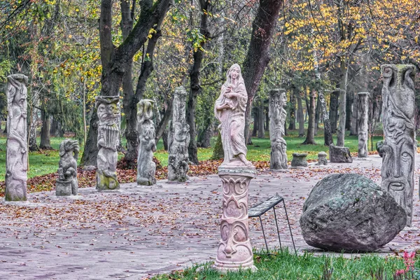 Autumn landscape - alley of chimeras with statues of monsters in the park of the city of Lutsk (Ukraine).